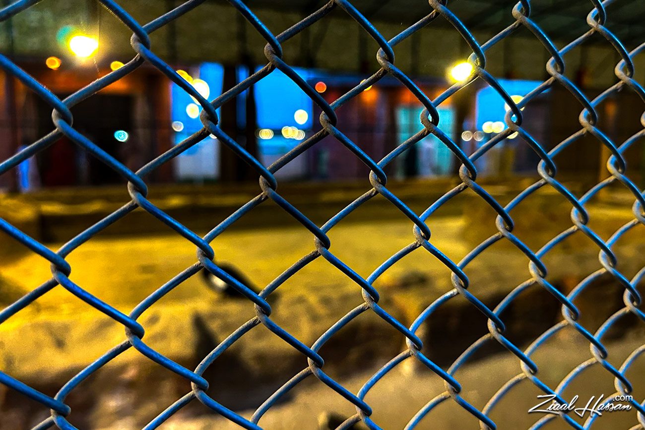 Urban Night Perspective Through Chain Link Fence - Dr. Zia-al-Hassan Photography