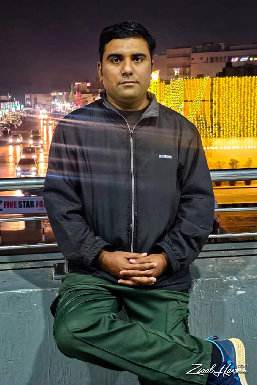 Portrait of Zeeshan Overlooking a Vibrant Night Cityscape - Dr. Zia-al-Hassan Photography